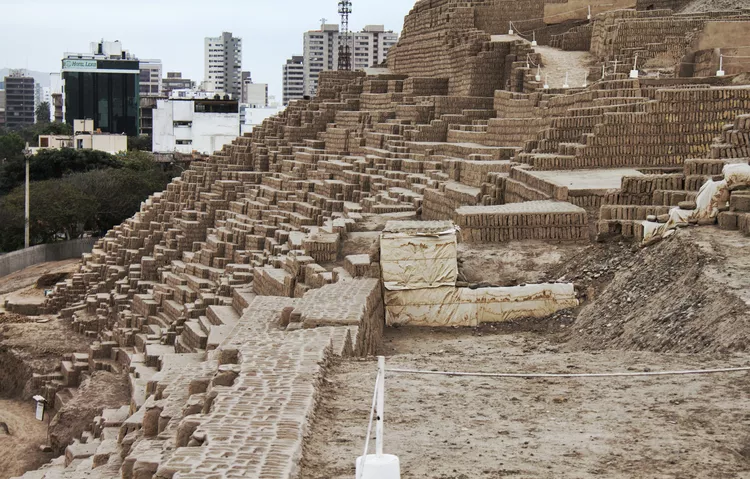 Huaca Pucllana archaeological ruins in Lima with city buildings in the background, historic site visited by travelers