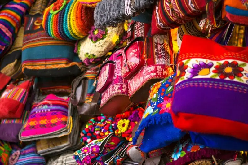 Traveler politely bargaining with a vendor at a traditional market in Peru.