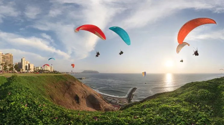 Tandem paragliding over Lima’s Costa Verde cliffs with Pacific Ocean views and Miraflores skyline